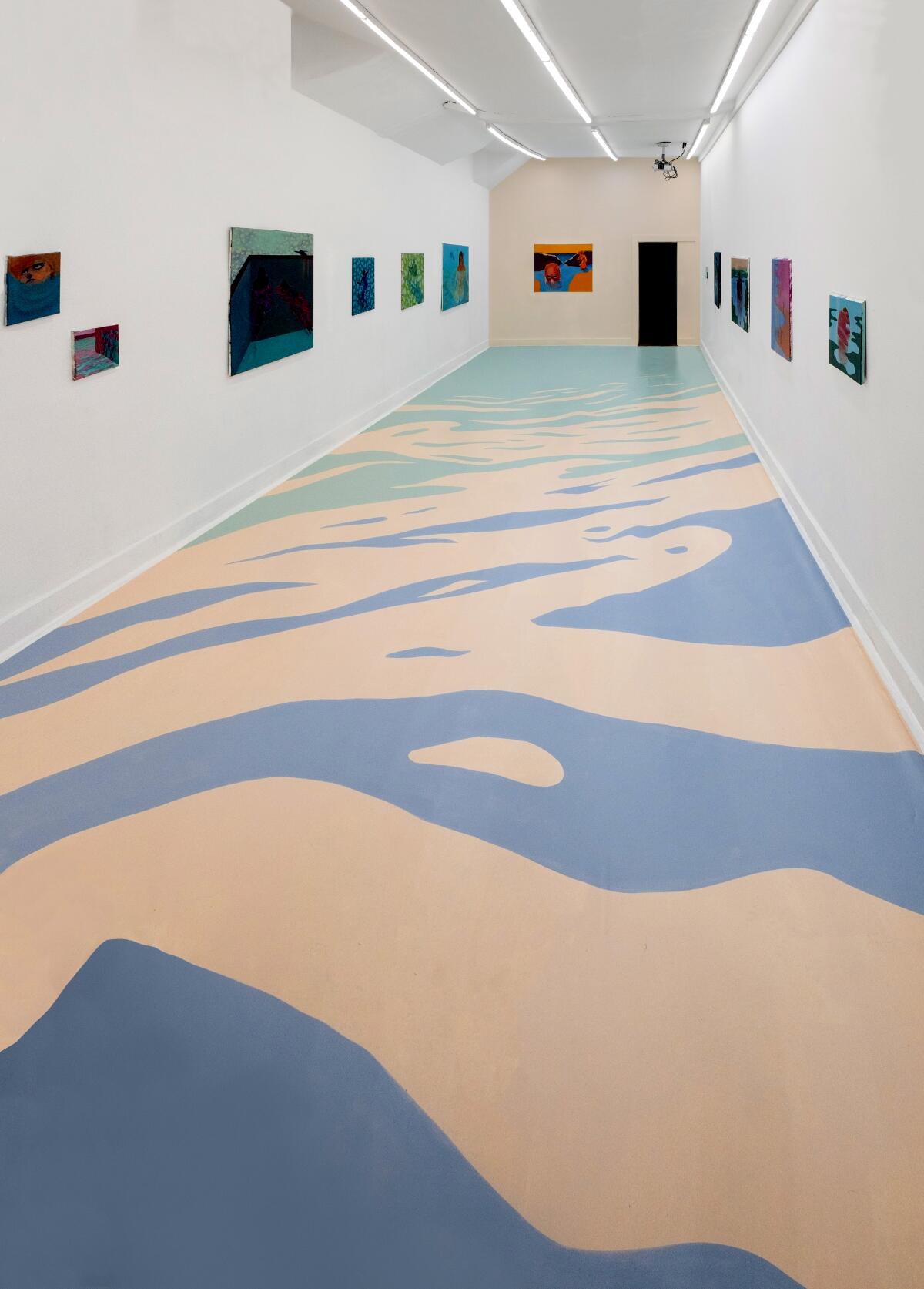 A gallery space with a painted floor and art on three white walls.