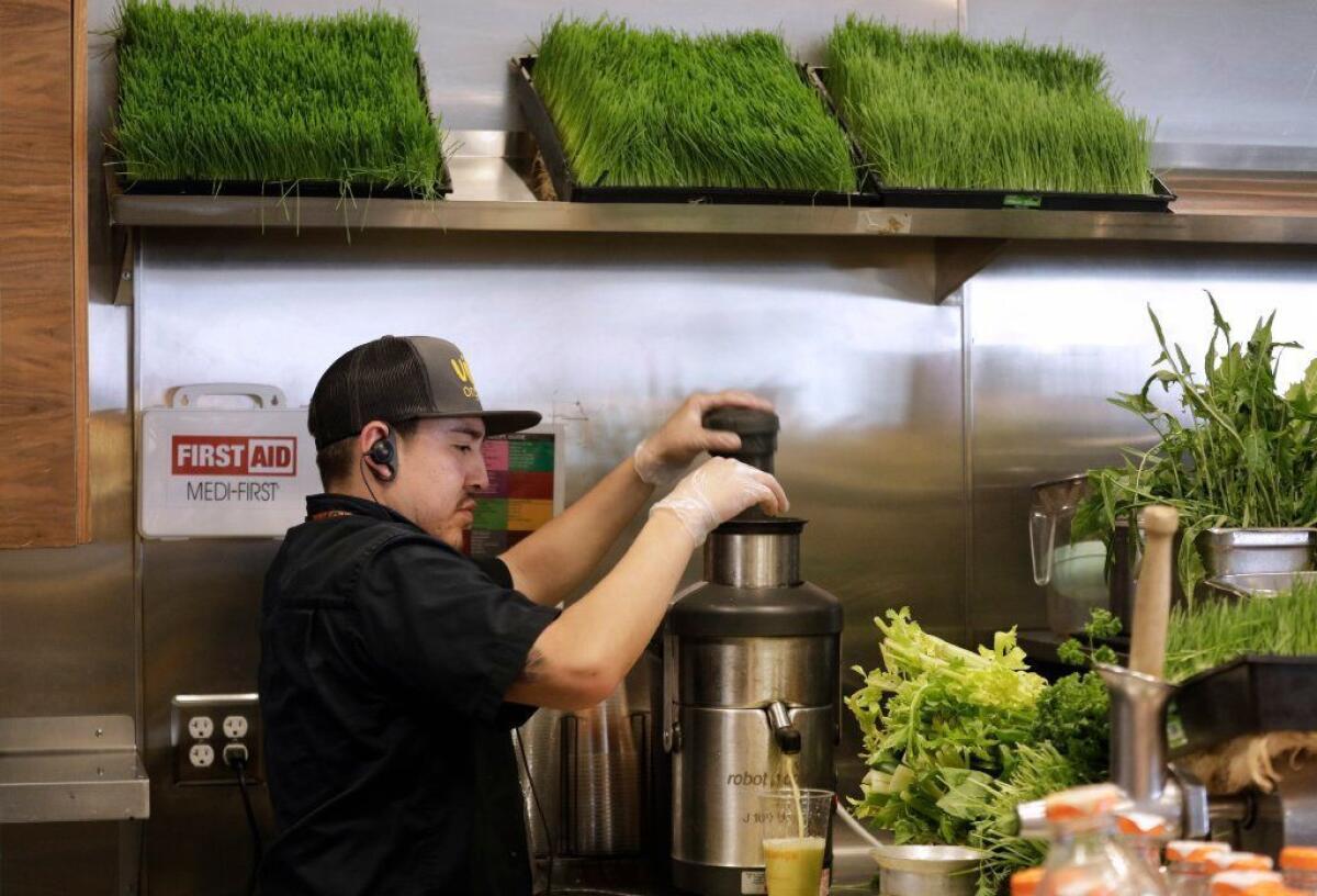 Angel Mack makes an order of celery juice at the Tonic Bar inside Erewhon Market.