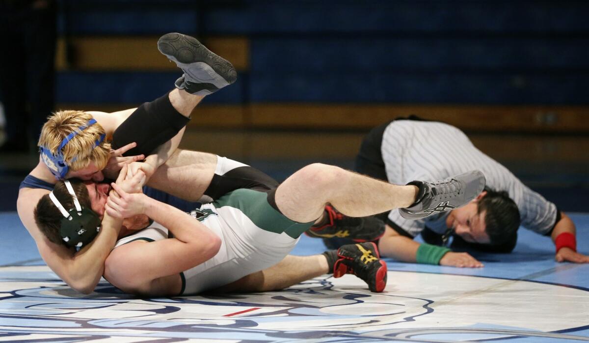 Corona del Mar's Cole Jensen tries to pin Irvine's Greg Codilian in a Pacific Coast League match on Wednesday.