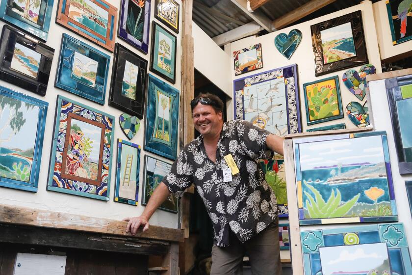 Artist Jesse Bartels, who works with mixed ceramic tiles, welcomes guests on opening day of the Sawdust Festival in Laguna Beach on Friday.