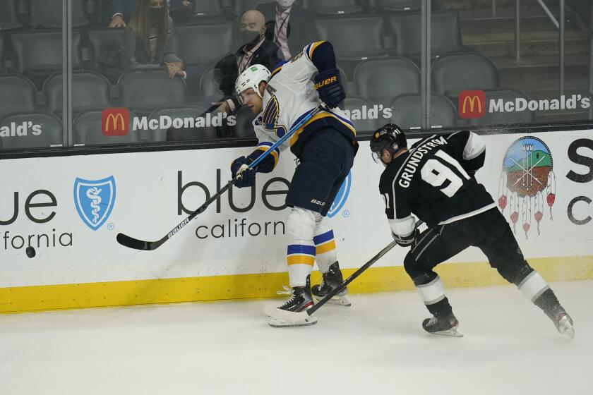 St. Louis Blues defenseman Colton Parayko (55) passes the puck ahead of Los Angeles Kings left wing Carl Grundstrom (91) during the second period of a hockey game Monday, May 10, 2021, in Los Angeles. (AP Photo/Ashley Landis)