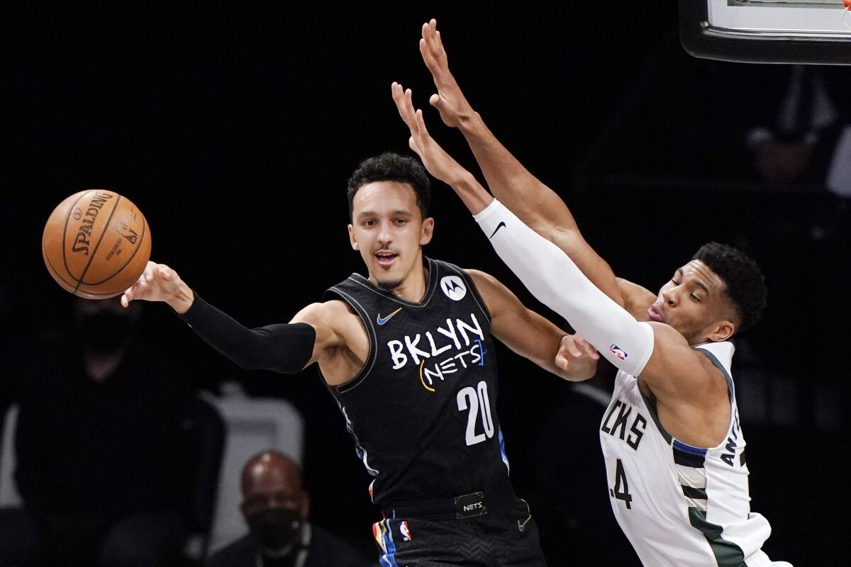 FILE - In this June 7, 2021, file photo, Brooklyn Nets guard Landry Shamet (20) passes the ball as Milwaukee Bucks forward Giannis Antetokounmpo (34) defends during the first half of Game 2 of an NBA basketball second-round playoff series in New York. The Brooklyn Nets acquired backup guard Jevon Carter and the draft rights to center Day’Ron Sharpe from the Phoenix Suns for guard Landry Shamet, the teams announced Friday, Aug. 6, 2021. (AP Photo/Kathy Willens, File)