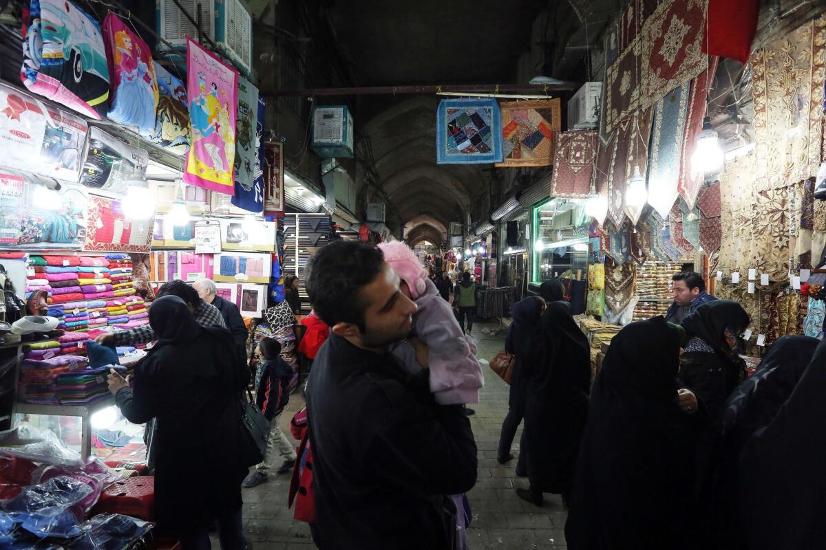 Iranians shop at the main bazaar in Tehran on Thursday. Sanctions have battered Iran's economy, with the inflation rate currently between 17 and 18%.