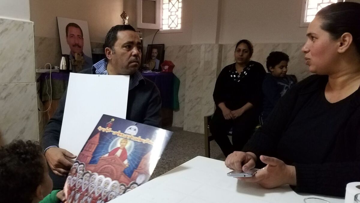 Emad Tawil, 53, left, talks about the loss of his wife and daughter in the Dec. 11 Cairo church bombing with Nadia Salah, 33, whose husband was also killed in the attack. Tawil shared Christmas calendars honoring the victims with Salah's 18 month-old son Fadi.