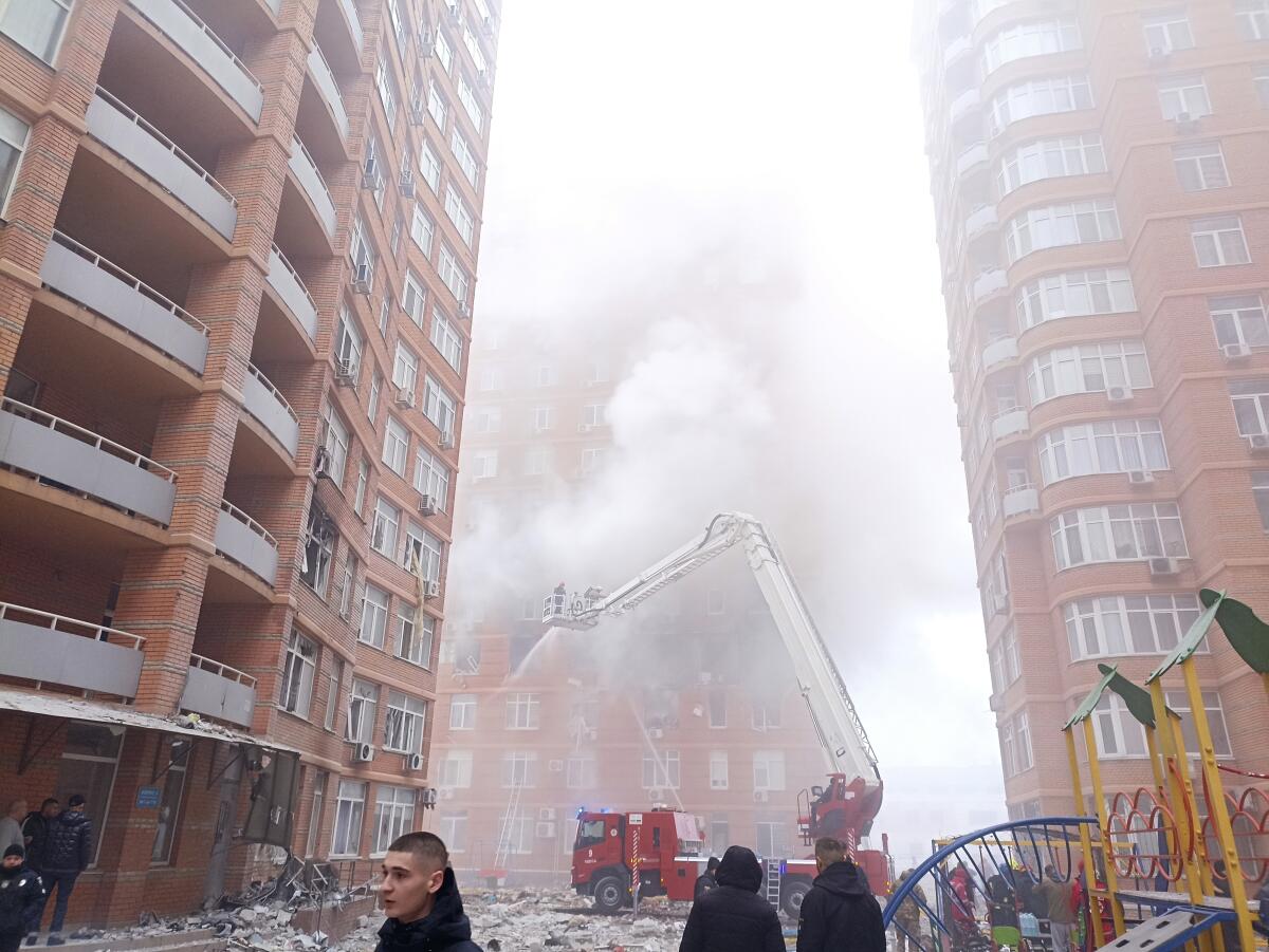 Firefighters work to extinguish a fire at a damaged apartment building after a Russian attack.