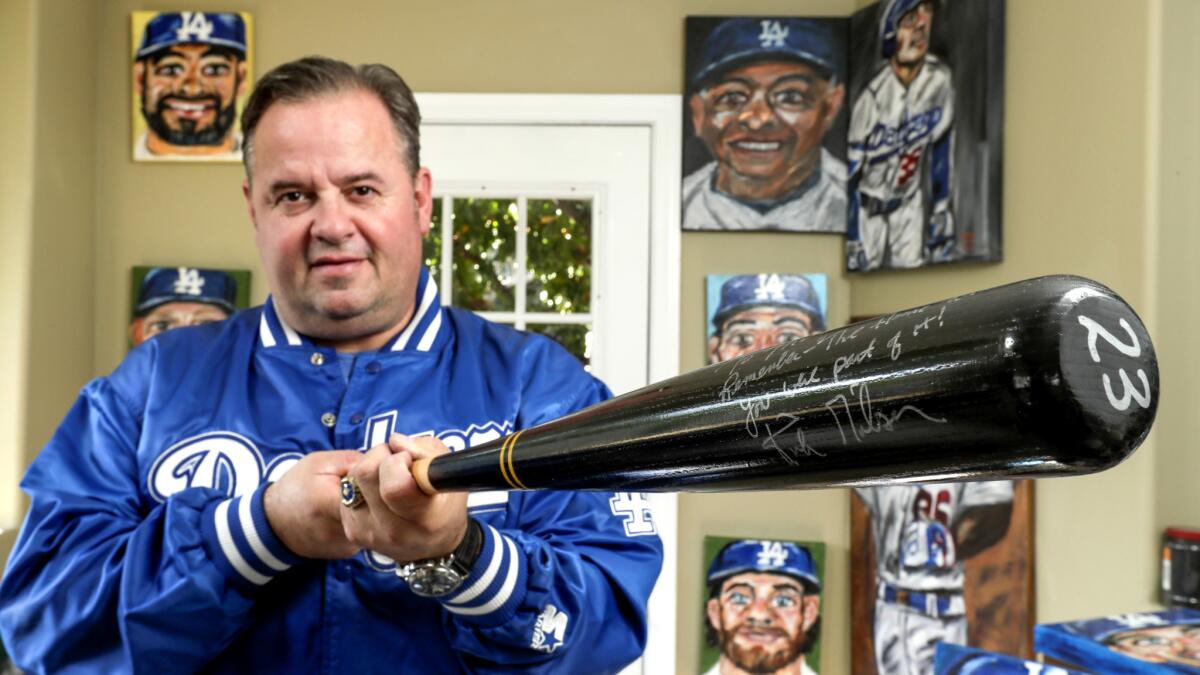 Mitch Poole, a Dodgers ballboy in 1988, holds a bat autographed by Kirk Gibson.