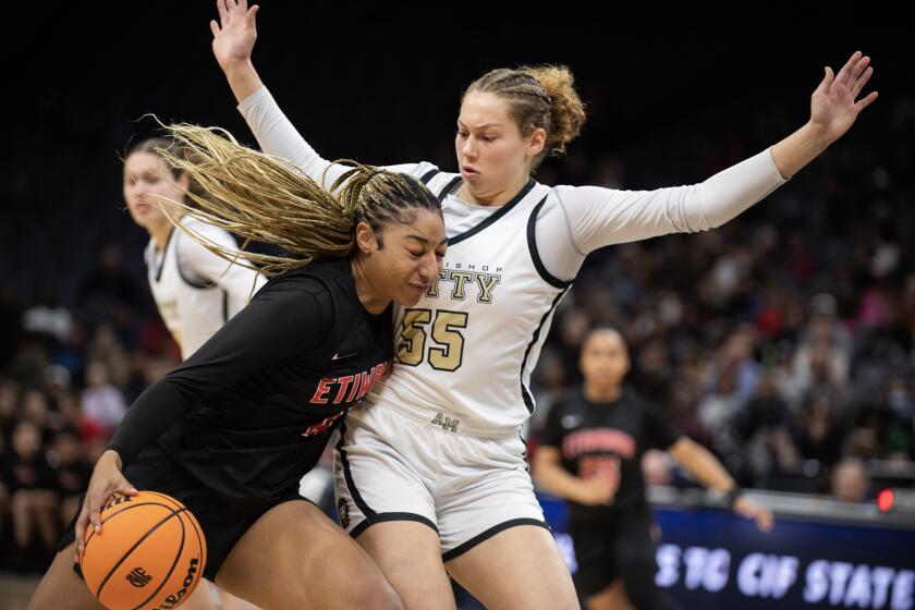 Mitty's Maya Hernandez (55) defends Etiwanda's Kennedy Smith (11) as she drives to the basket in the first half of the Open Division Girls State Championship basketball game at the Golden 1 Center in Sacramento, Calif., Saturday, March 11, 2023. (Photo/Jose Luis Villegas)