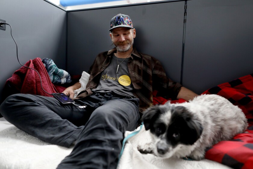 Daniel Gomer McMillan, 46, with his dog, Pushoe, at the new, 72-bed homeless shelter in Hollywood. The shelter on Schrader Boulevard is the second to open under Mayor Eric Garcetti's "A Bridge Home" program.