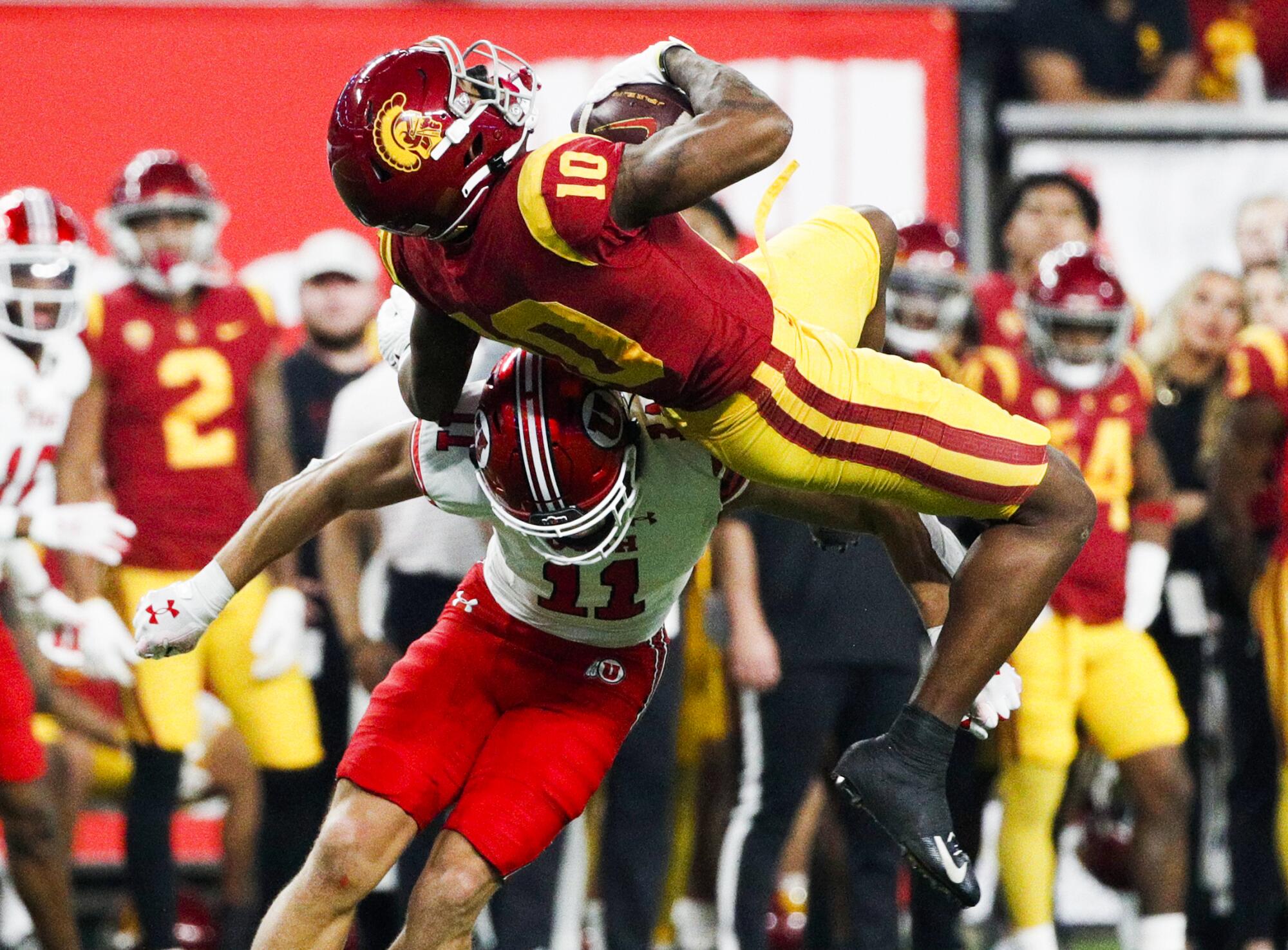 USC wide receiver Kyron Hudson (10) makes a leaping catch over Utah safety R.J. Hubert.