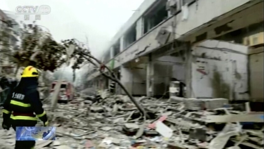 In this image taken from a video footage run by China's CCTV, a firefighter walks near the aftermath of a gas explosion in Shiyan city in central China's Hubei Province on Sunday, June 13, 2021. At least a dozen people were killed and more seriously injured Sunday after a gas line explosion tore through the residential neighborhood in central China. (CCTV via AP Video)