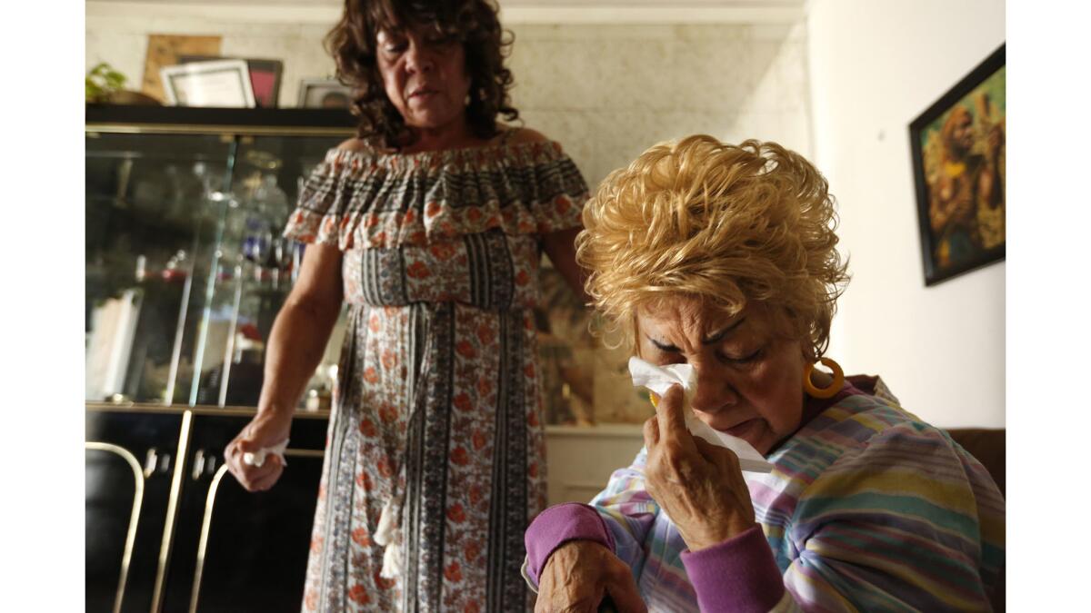 Ossie Hill, 86, right, cries over the possibility of foreclosure of her Los Angeles home as her daughter Cassina Edwards, 59, looks on. Hill is facing annual payments of $5,500 for a roughly $50,000 loan through the PACE program.