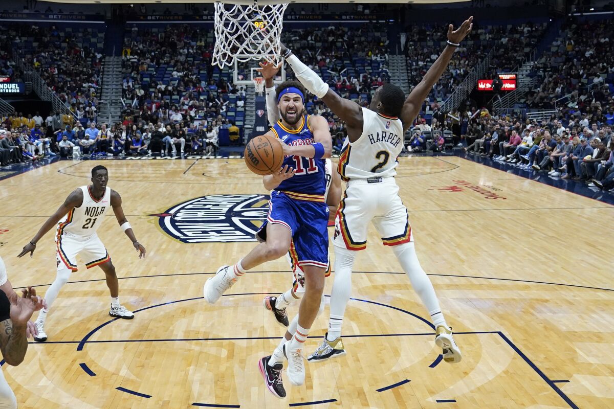 Golden State Warriors guard Klay Thompson (11) goes to the basket against New Orleans Pelicans guard Jared Harper (2) in the second half of an NBA basketball game in New Orleans, Sunday, April 10, 2022. The Warriors won 128-107. (AP Photo/Gerald Herbert)