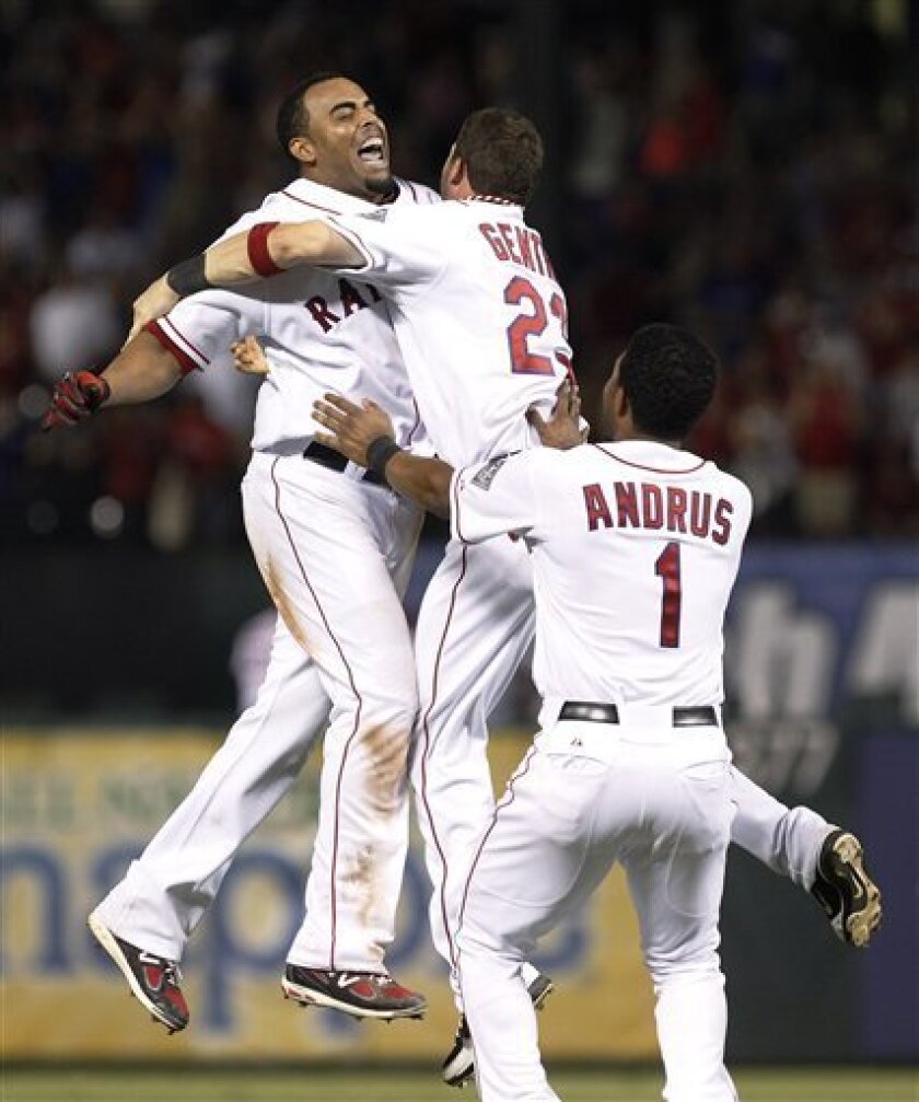 Texas Rangers' Nelson Cruz, left, celebrates with teammates Craig Gentry (23) and Elvis Andrus (1) after Cruz's game-winning RBI double in the 10th inning of a baseball game against the Minnesota Twins on Saturday, July 7, 2012, in Arlington, Texas. Adrian Beltre scored the winning run for the 4-3 victory. (AP Photo/LM Otero)