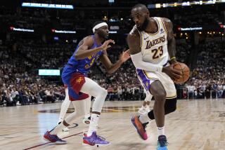 Los Angeles Lakers forward LeBron James (23) is pressured by Denver Nuggets forward Justin Holiday.