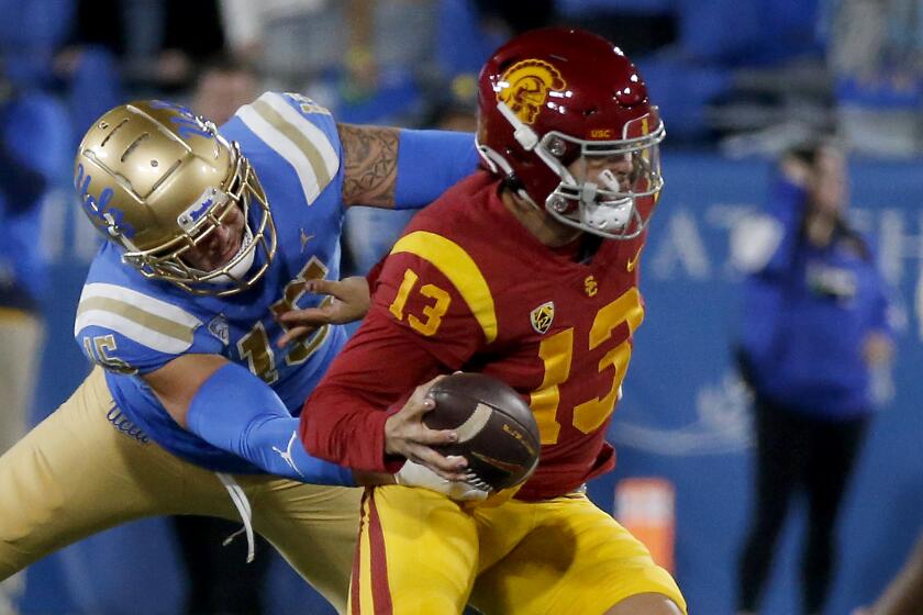 USC quarterback Caleb Williams avoids a sack by UCLA linebacker Lalatu Latu