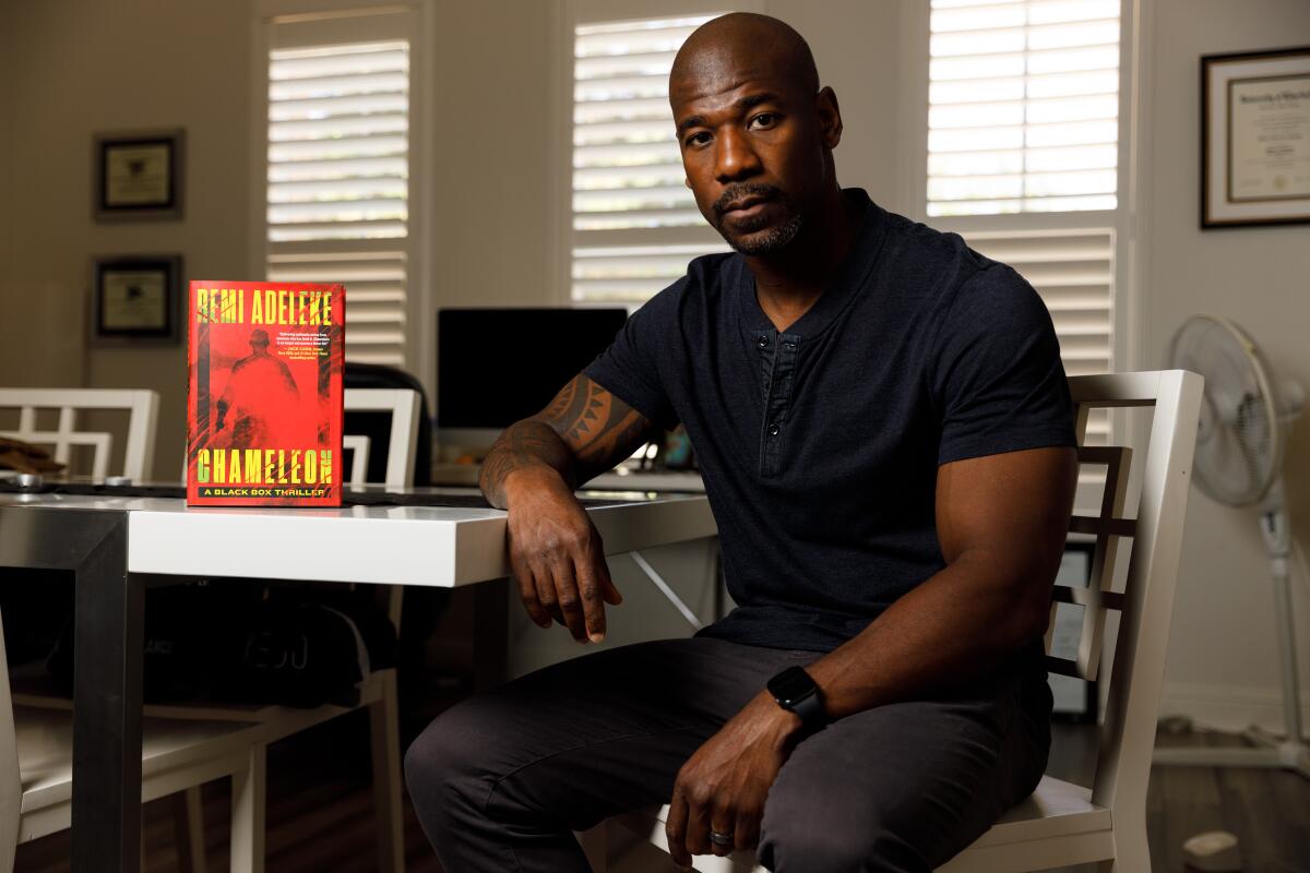 Former Navy SEAL Remi Adeleke with his new book, “Chamelon,” at his home in Chula Vista on  Aug. 7, 2023.
