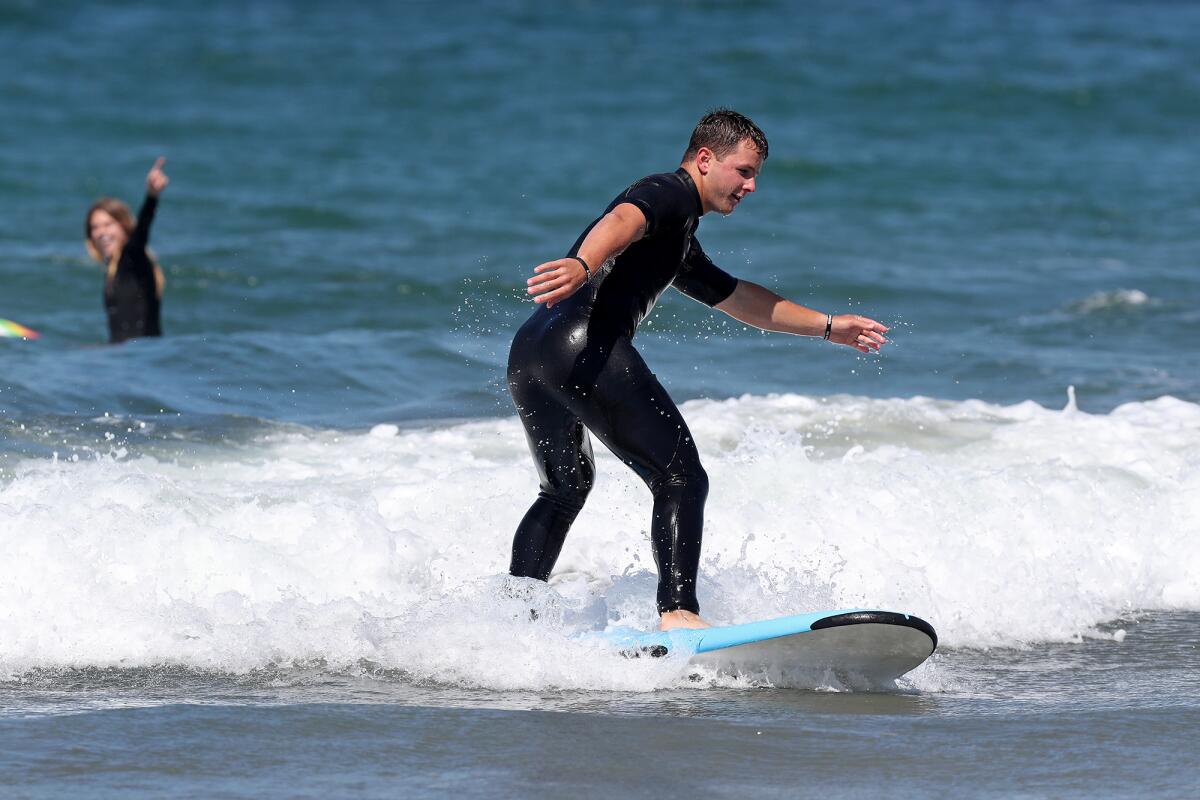 Mr. Irrelevant Brock Purdy rides a wave during surf lessons near 30th Street and West Oceanfront on Thursday.