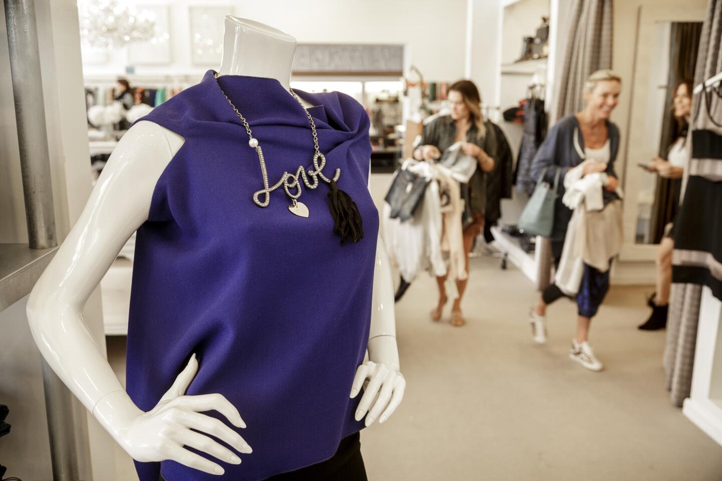 The Antioch Street boutique is famous for Walker's attentiveness to clients and the mix of casual and designer. Here, a Roland Mouret blouse is paired with a Lanvin Love necklace, while customers wander the store.