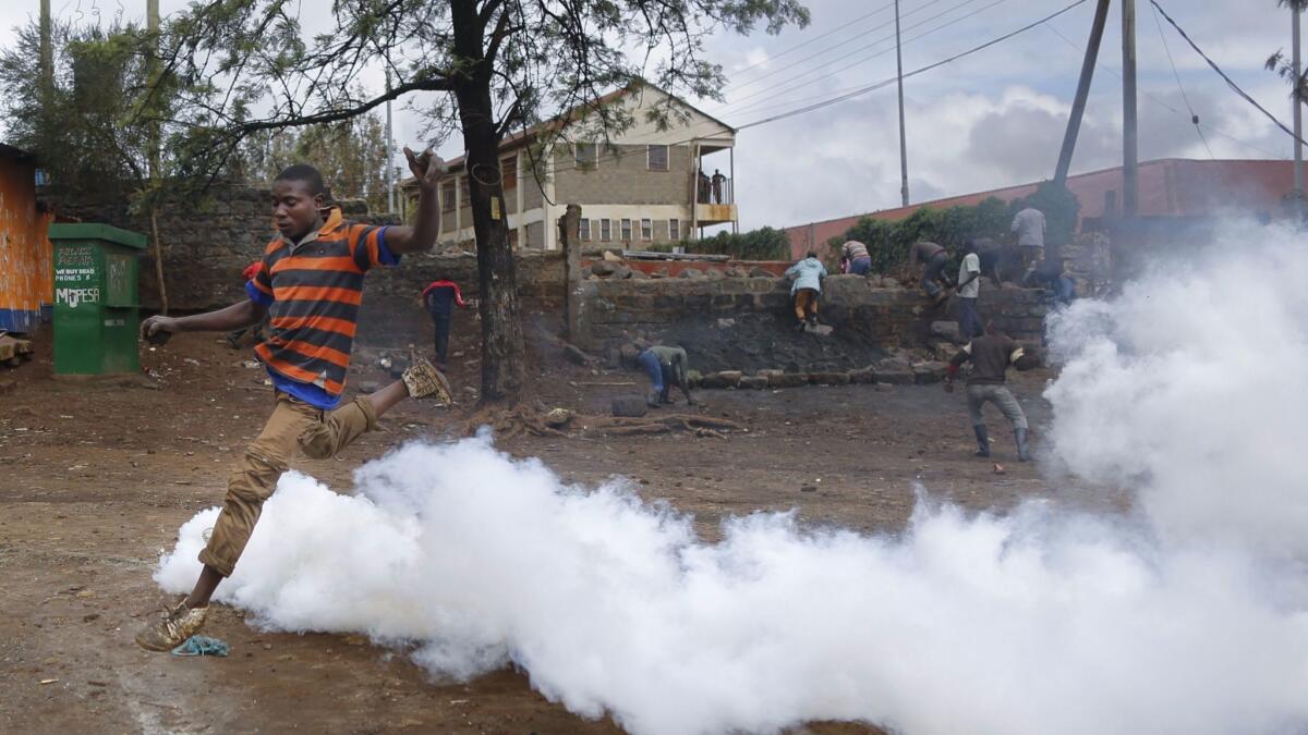 A supporter of opposition presidential candidate Raila Odinga jumps over a cloud of tear gas fired by police in Nairobi's Kibera slum.