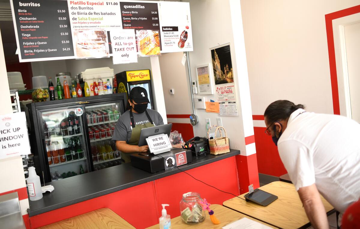 A customer pays for his food at Burritos La Palma