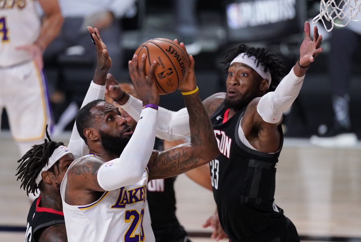 Los Angeles Lakers' LeBron James (23) drives to the basket past Houston Rockets' Robert Covington (33) during the first half of an NBA conference semifinal playoff basketball game Tuesday, Sept. 8, 2020, in Lake Buena Vista, Fla. (AP Photo/Mark J. Terrill)