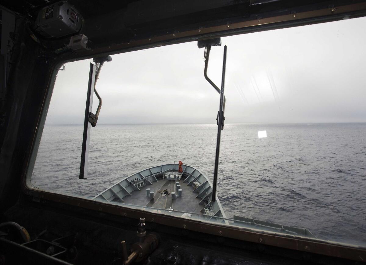 A lookout scans the ocean from the Australian navy ship Success, which is assisting in the search for Malaysia Airlines Flight 370 in the Indian Ocean.