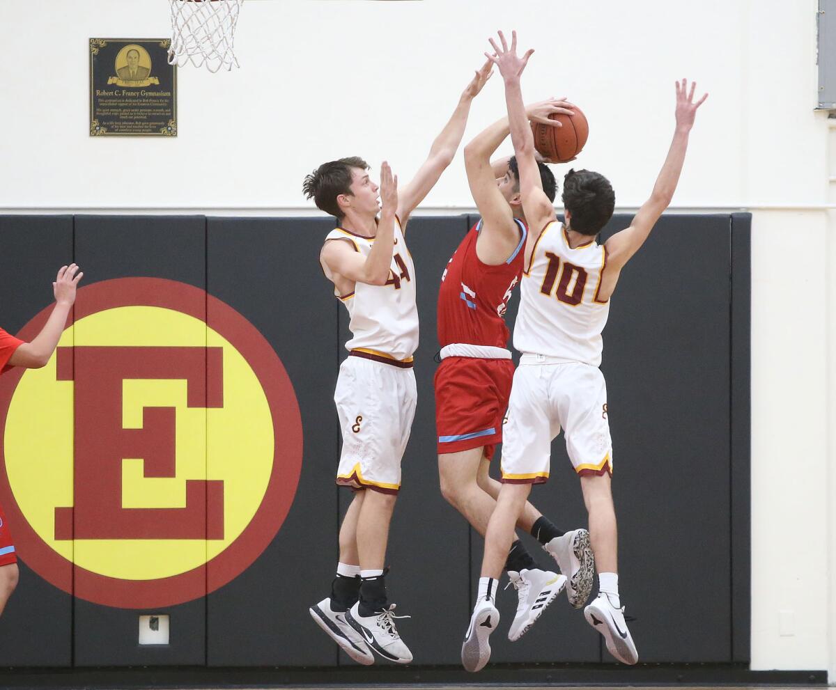 Estancia’s Jake Covey (44) and Bo Graham (10) block a shot attempt by Santa Ana’s Kristian Soto during an Orange Coast League game on Wednesday.