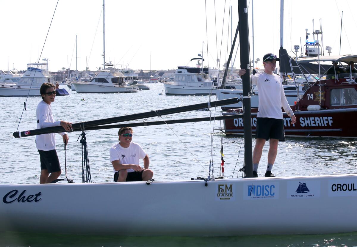 Jordan Stevenson, right, Mitch Jackson, left, and George Angus of the Royal New Zealand Yacht Squadron sail into the harbor.