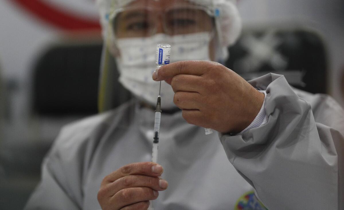 Healthcare worker preparing dose of Russia's COVID-19 vaccine