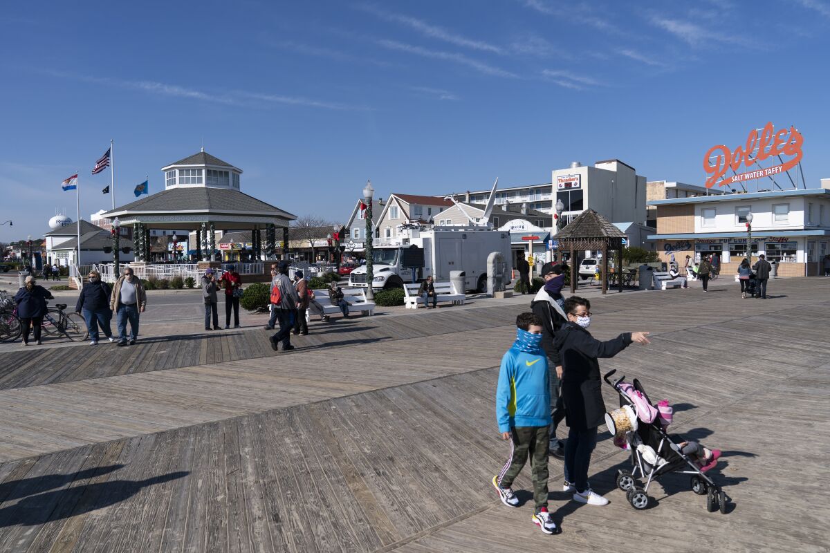 People enjoy the boardwalk, Friday, Nov. 13, 2020, in Rehoboth Beach, Del. This resort town known for Atlantic waves that are sometimes surfable, fresh-cut French fries and a 1-mile wooden boardwalk that dates back to the 1870s has long prided itself on being the “Nation's Summer Capital.” (AP Photo/Alex Brandon)