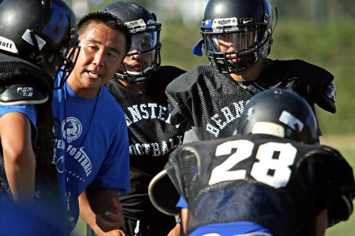 Bernstein Coach Masaki Matsumoto, second from left, works with Dragons players. Matsumoto asked parents to write letters of support for their sons on the team, borrowing the notion from coaches at Bothell High near Seattle.