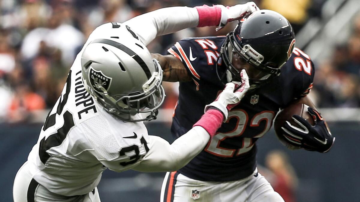 Bears running back tries to fend off a tackle by Raiders safety Neiko Thorpe in the first half Sunday.