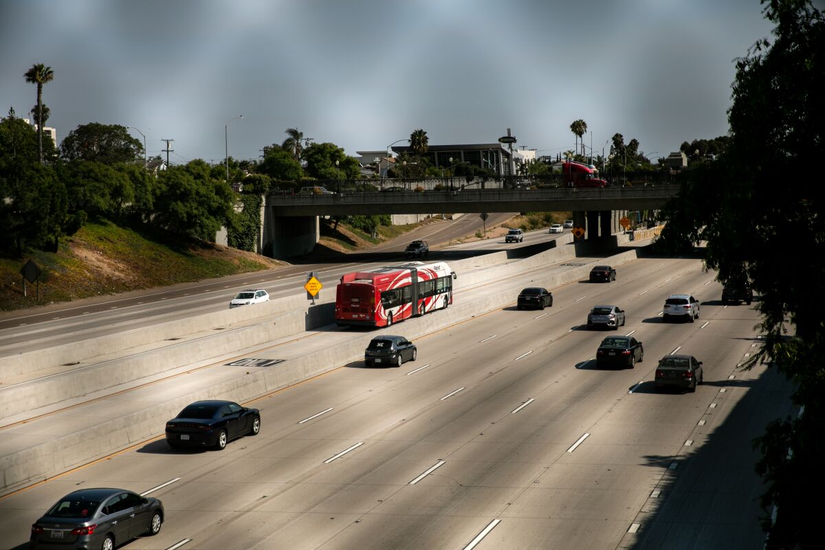 A Metropolitan Transit System bus drives along Interstate 15 on Friday, Aug. 14, 2020 in San Diego.