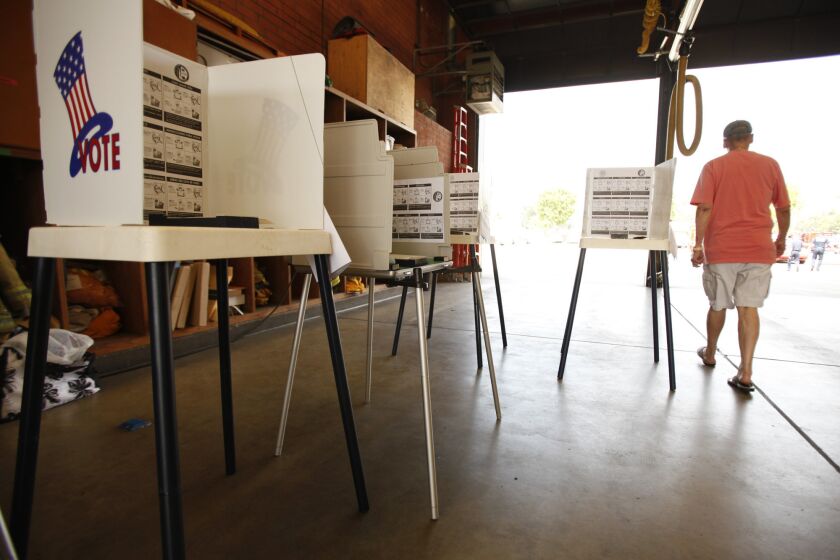 Jay Goldfard of Encino walks past empty voting booths after bringing his mail ballot to the Los Angeles City Fire Station 88 in Sherman Oaks on Tuesday, May 21, 2013.