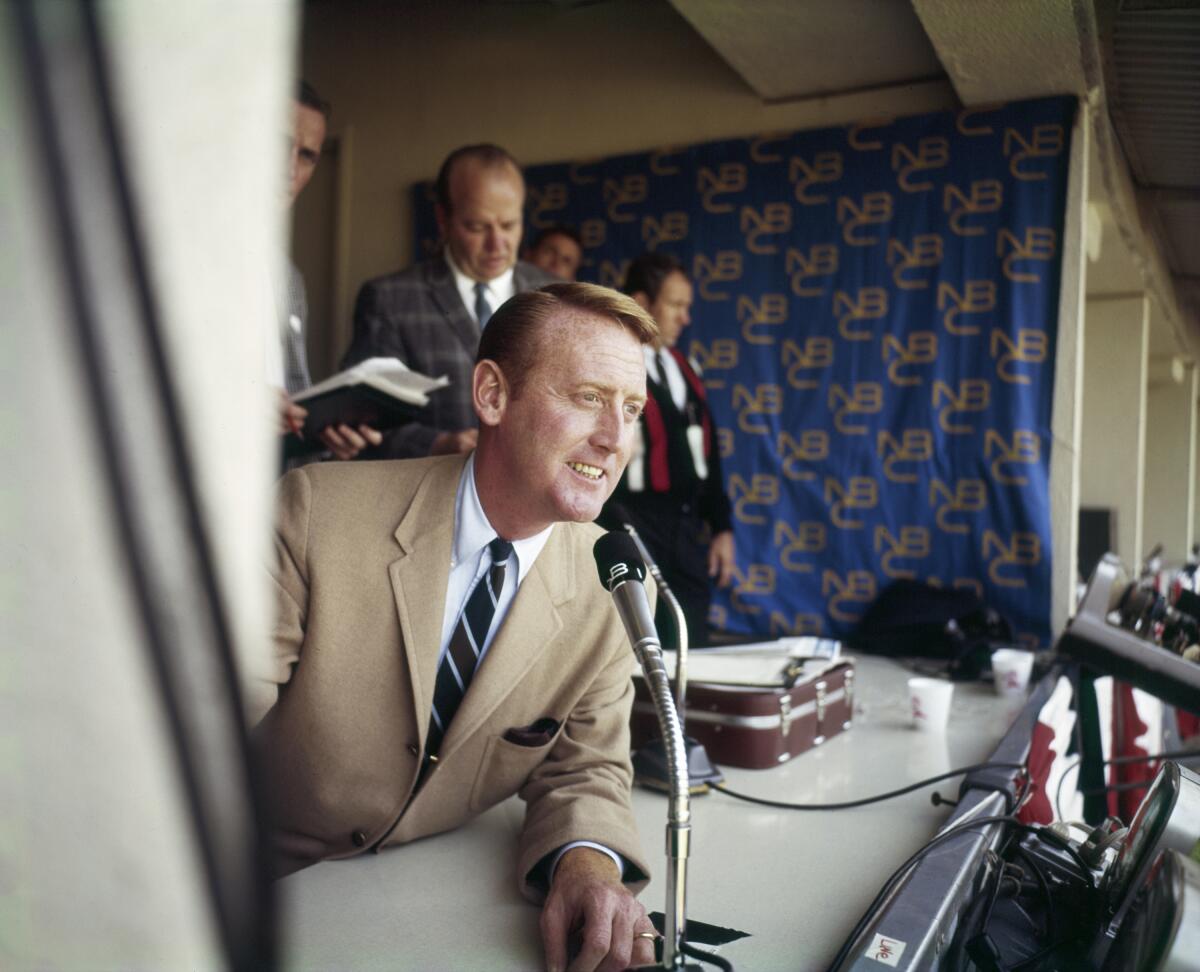 Vin Scully leans out of the press box during the 1960s 