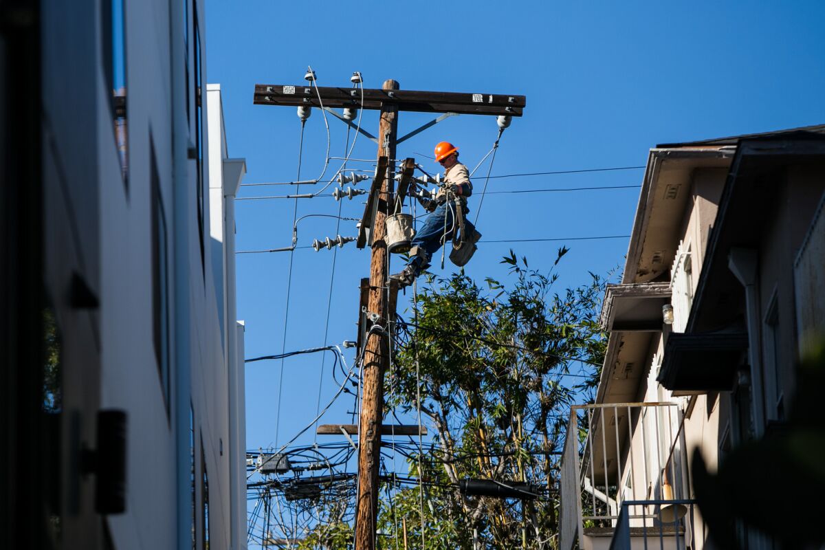 Michael McGuire repairs power lines that were damaged by high winds in Century City on Dec. 25.