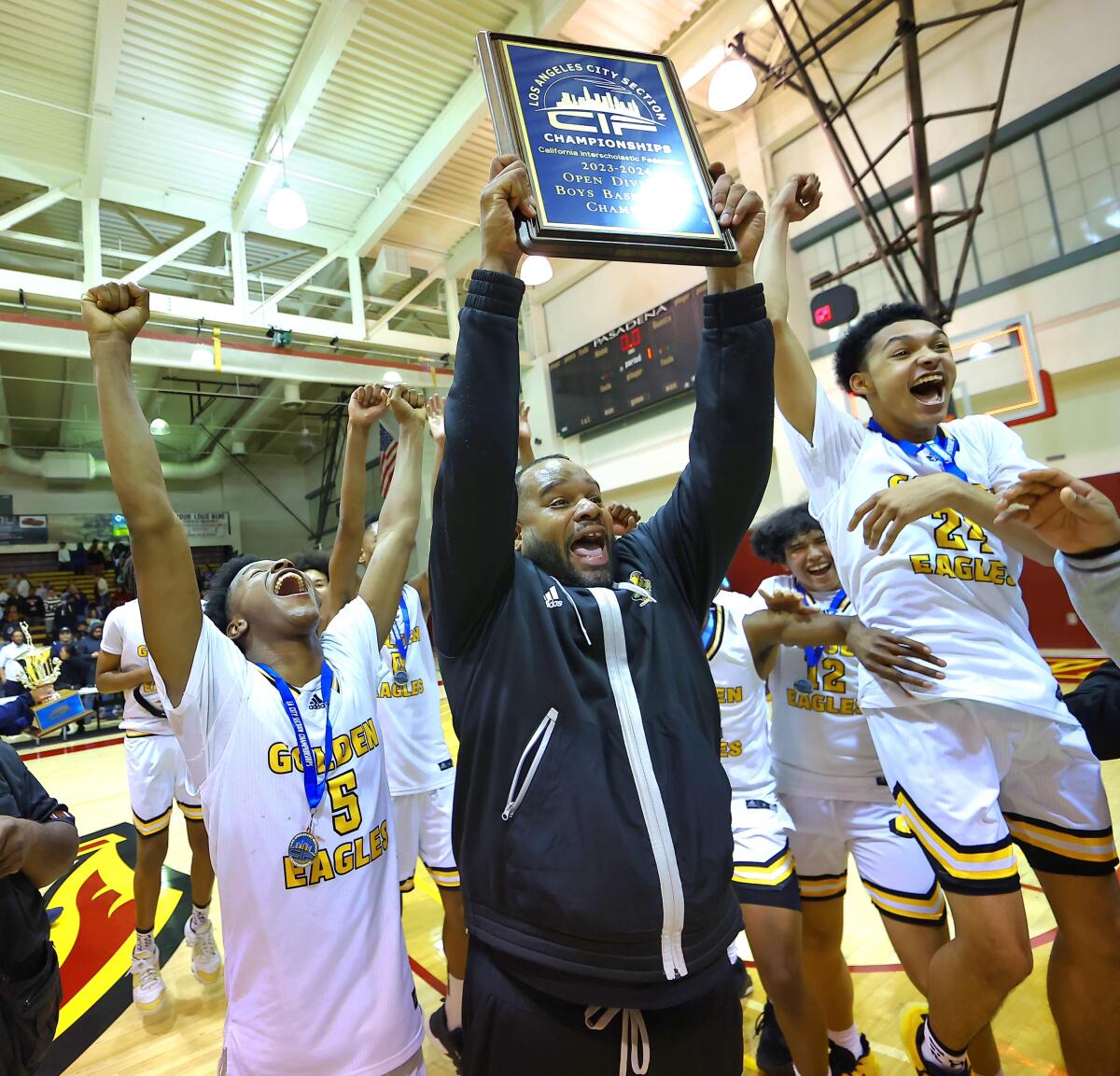 King/Drew coach Lloyd Webster and players celebrate City Section Open Division championship.