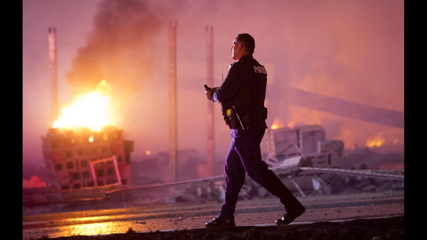 A police officer walks by a blaze.