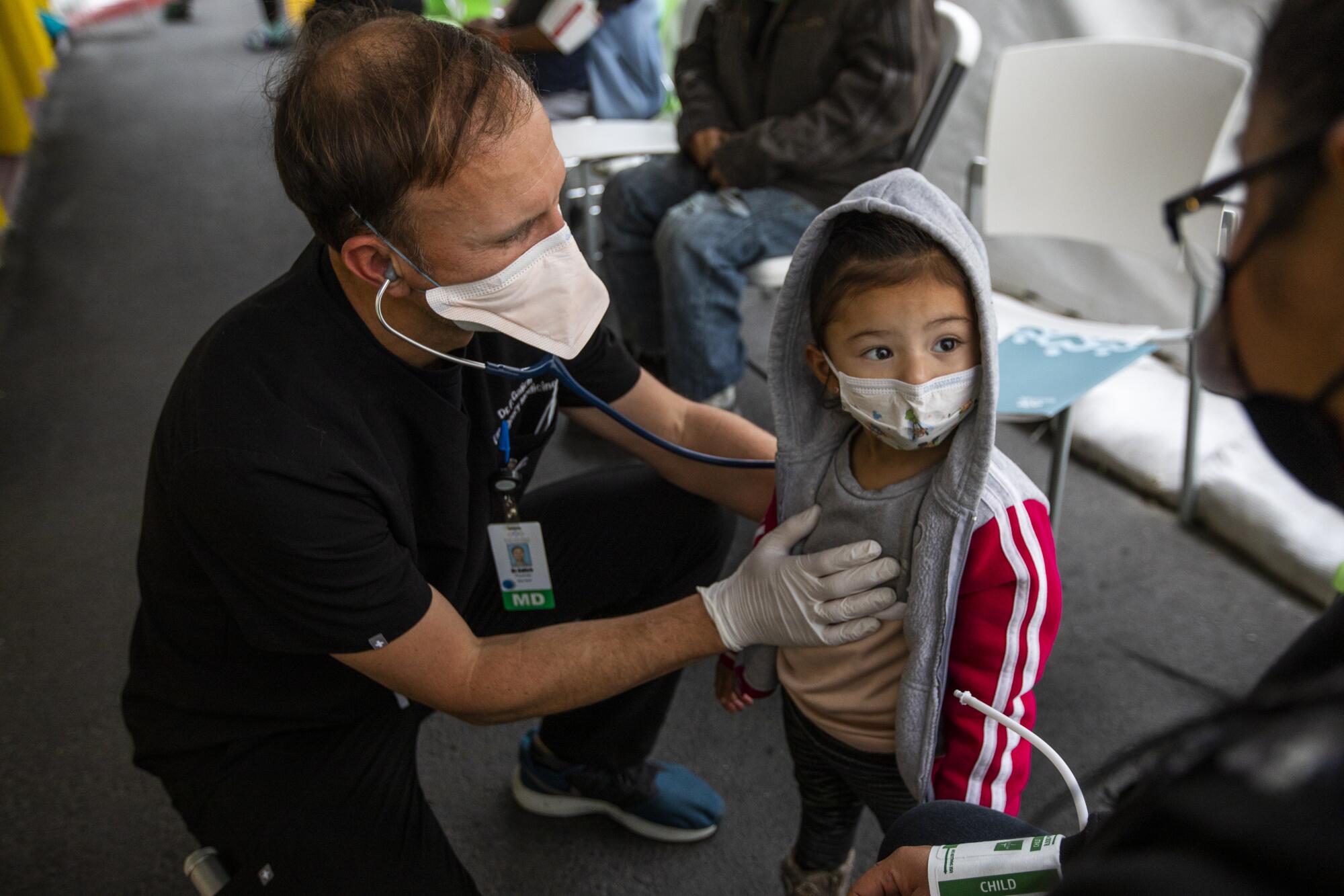 A doctor uses a stethoscope on a toddler