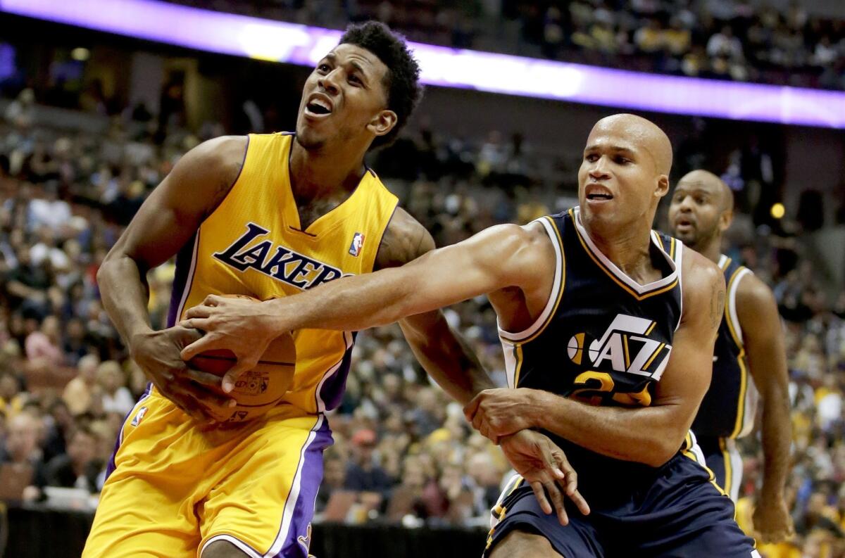 Lakers guard Nick Young, left, is fouled by Utah Jazz forward Richard Jefferson during the first half of the Lakers' 111-106 preseason win Friday at Honda Center.
