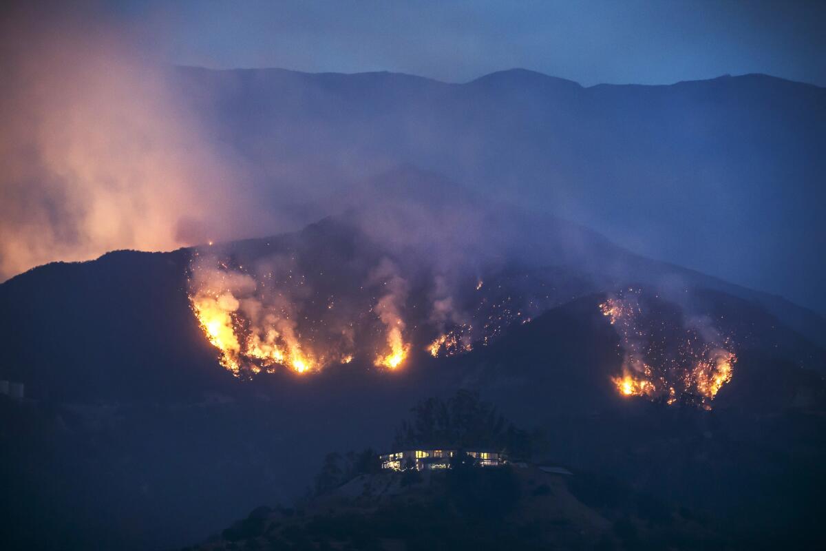 The Thomas fire makes its way down a ridge, threatening homes in Montecito on Monday.