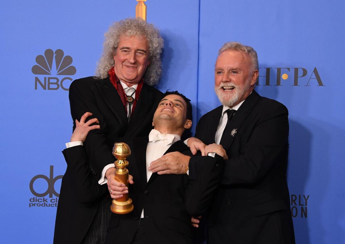 El actor Rami Malek posa con los miembros de Queen Roger Taylor (d) y Brian May (izq) tras ser premiado en los Globos de Oro.