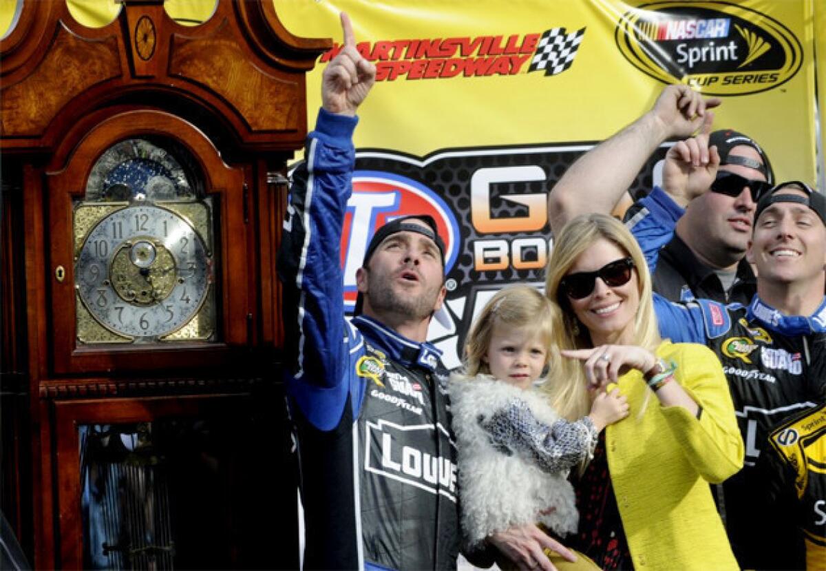 Jimmie Johnson, left, celebrates winning the STP 500 Sprint Cup series auto race with his wife, Chandra, and daughter, Genevieve.