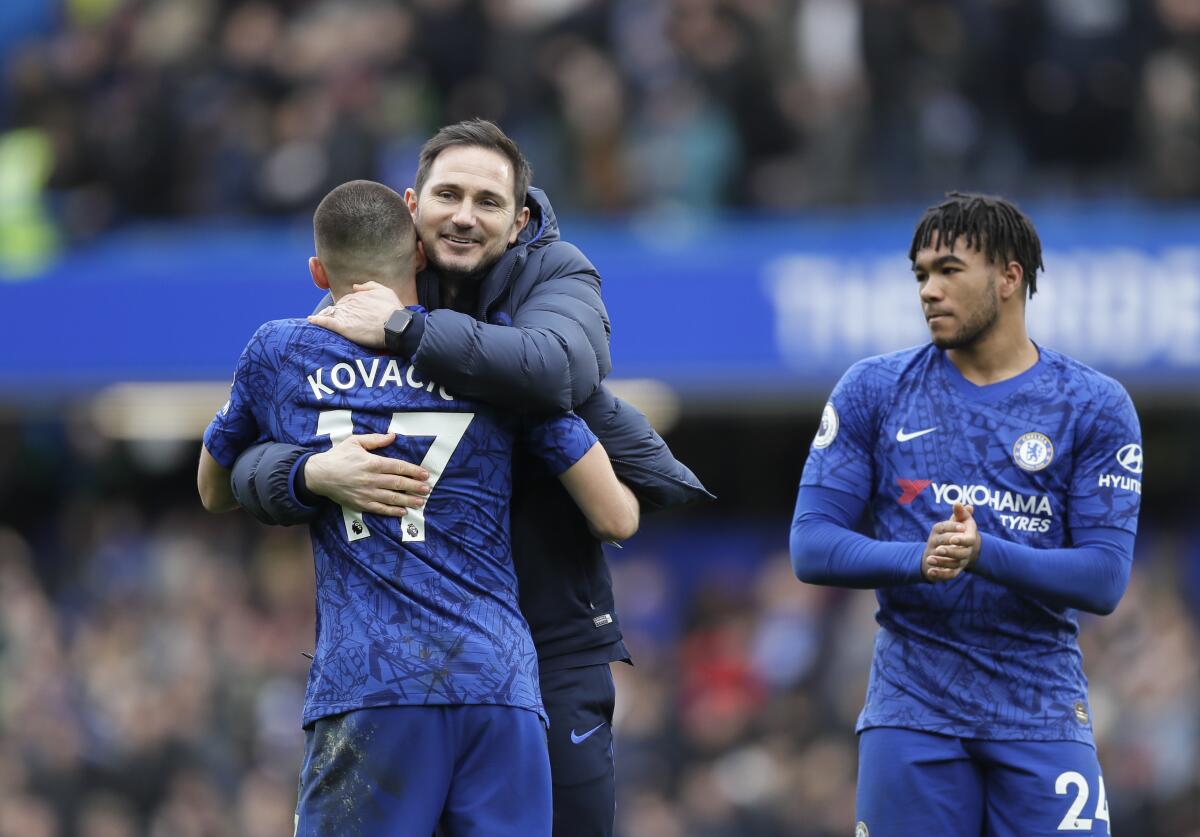 El técnico del Chelsea Frank Lampard, centro, abraza a Mateo Kovacic, con Reece James aplaudiendo a un lado luego de que el equipo venció al Tottenham 2-1 en la Liga Premier inglesa, el sábado 22 de febrero de 2020, en Londres. (AP Foto/Kirsty Wigglesworth)