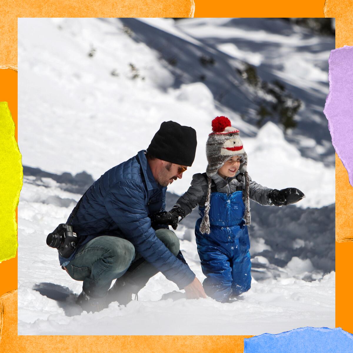 A man and a toddler play in the snow.