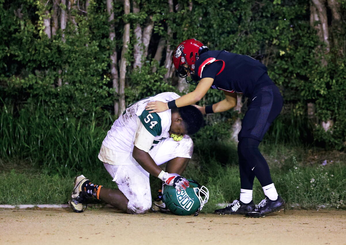 South Gate quarterback Michael Gonzalez tries to console William Smith of Dorsey
