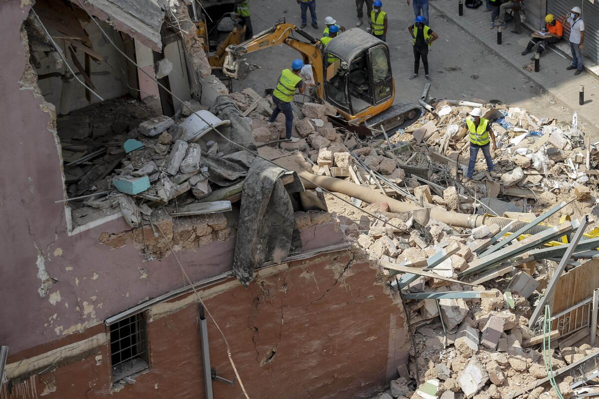 Rescuers search at the site of a collapsed building after getting signals there may be a survivor under the rubble.