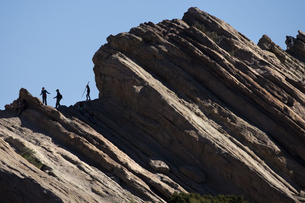 People walk among the jutting rock formations at Vasquez Rocks