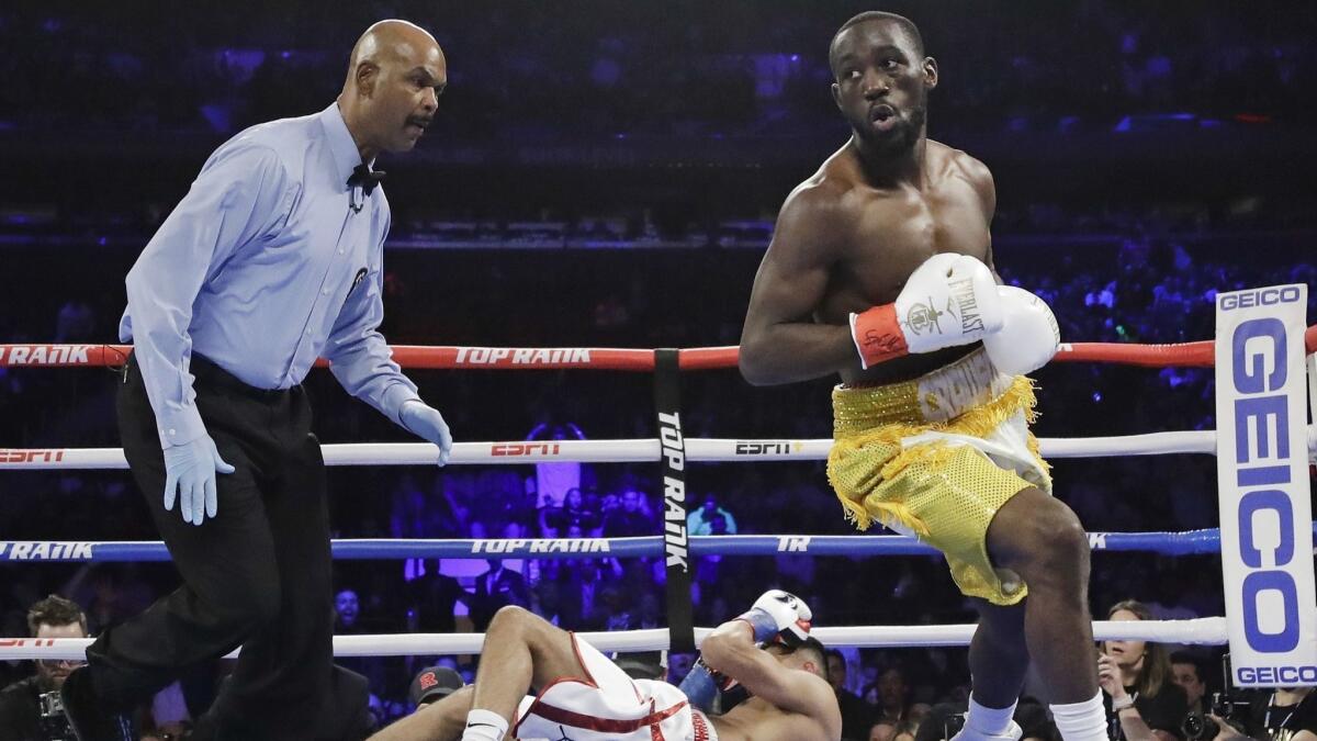 Terence Crawford, right, reacts after knocking down Amir Khan during the first round.