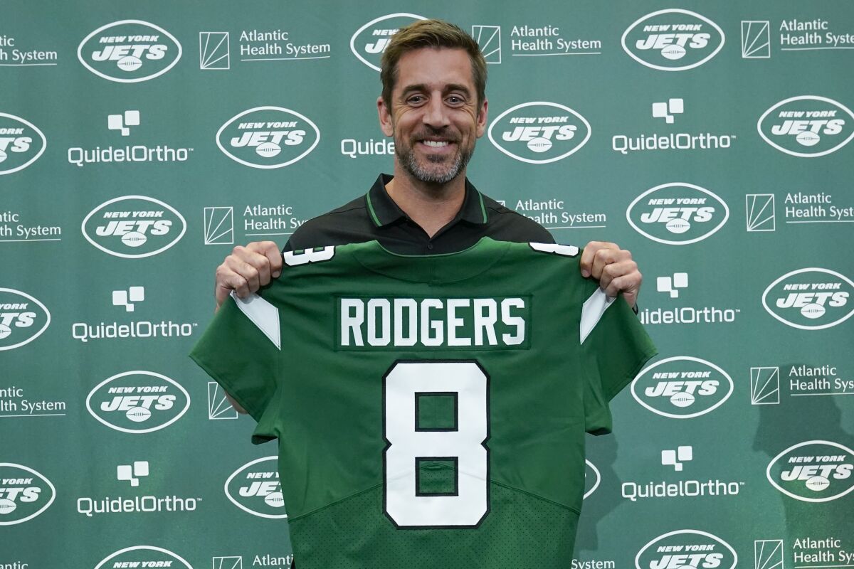 New York Jets' quarterback Aaron Rodgers displays his new No. 8 jersey. 